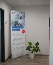 Ein Gang mit einem Pappaufsteller der WBS TRAINING und einer Zimmerpflanze.