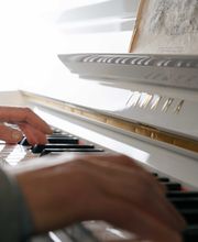 Hände spielen auf einem weißen Yamaha-Klavier