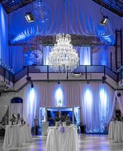 Die Palazzo Halle in Karlsruhe – Ihre perfekte Eventlocation für unvergessliche Veranstaltungen wie Firmenfeiern, Produktpräsentationen, Tagungen, Hochzeiten und mehr.
Die ehemalige Maschinenfabrik am Westbahnhof in Karlsruhe bildet ein außergewöhnliches Ambiente für exklusive Veranstaltungen mit dem gewissen Etwas. Auf 1.000 Quadratmetern ermöglicht die flexible Raumeinteilung den passenden Rahmen für jede Art von Event – von privaten Feiern wie Hochzeiten oder Geburtstage bis hin zu geschäftlichen Events wie Tagungen, Konferenzen oder Produktpräsentationen. In den Abendstunden taucht die ausgeklügelte Beleuchtungstechnik die hohen Decken in unterschiedliche Lichtstimmungen und macht die Palazzo Halle zu einer einmaligen Eventkulisse. Die Halle kann über die Eventagentur Projekt Eins gemietet werden, die das Lichtkonzept, die Dekoration, das Catering und auf Wunsch auch ein Rahmenprogramm detailliert auf das jeweilige Thema der Veranstaltung abstimmt.