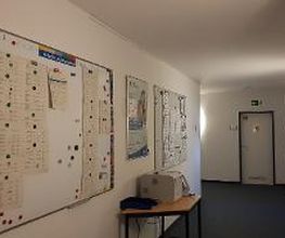 Flur mit 2 Whiteboards auf den Informationszettel hängen. Druckstation mit Papierablage.
