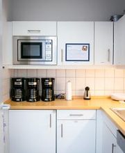 Eine voll ausgestattete Küche mit weißen Schränken.