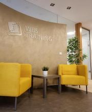 Wartebereich mit zwei gelben Sesseln und Tisch.