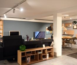 Moderner Wohnbereich mit elegantem Sofa, Holz-Media-Möbeln und stilvoller Wandgestaltung bei Möbel Schmitz in Trier. Ihr Experte für ganzheitliches Interior Design und Markenmöbel.