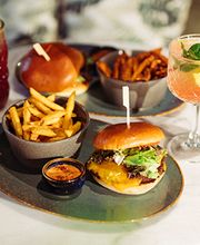 Alle unsere Burger werden in einem Brioche Bun und mit Tomaten, Salat und Mauri Dressing serviert. Sie können wahlweise mit Pommes oder Beilagensalat bestellt werden.