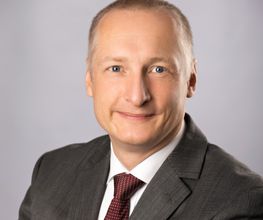 Portrait des Standortleiters. Ein Mann im Anzug mit Krawatte.