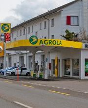 AGROLA Tankstelle in Elgg bei Renault Garage; geschwungenes Dach; Tankstelle mit zwei Tanksäulen; an Dach digitale Preisanzeige mit AGROLA Logo, Strasse im Vordergrund