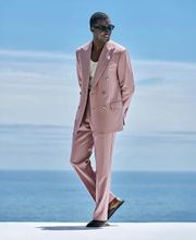 This purple suit is cut to a tailored fit, offering an elegant silhouette with structured shoulders. Paired with flat-front trousers featuring belt loops for a sleek, modern look.