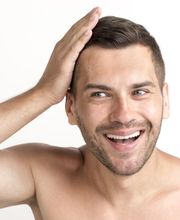 smiling-young-shirtless-man-touching-his-hair-white-backdrop-1024x683.jpg