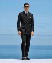 This black striped suit is cut to a tailored fit, offering a refined silhouette with structured shoulders. Paired with slim trousers featuring side-adjusters and a flat front for modern sophistication.