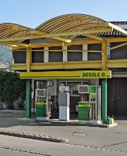 AGROLA Tankstelle in Altstätten, St. Gallen, Überdachung, gelbes Gerüst. Zwei Tanksäulen mit einem Zahlterminal. Im Hintergrund Wohnhaus.