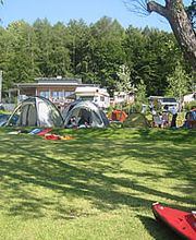Blick vom See auf Zeltplatz und Gebäude
