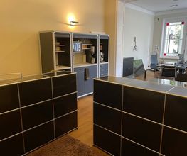 Seitlicher Einblick in die modern eingerichteten Büroräume der PAKT Gruppe mit Arbeitsplätzen und offenem Empfangsbereich.