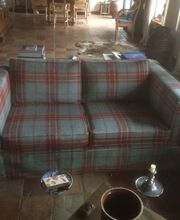 Martin Otto Thie Raumgestaltung Inh. Aline Sander e.K. handgefertigtes Sofa mit kariertem Wollstoff in warmem Wohnambiente. Kombination aus traditionellem Design und hochwertiger Polsterarbeit für ein gemütliches Raumgefühl.