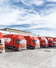 DELTA Logistik LKW-Flotte auf Firmengelände mit mehreren roten Transportern