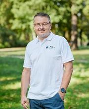 Mann mit Brille im weißen Polohemd, auf das das WBS TRAINING Logo gestickt ist.
