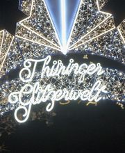 Spektakuläre Lichtinstallation mit goldener Funkenrad-Skulptur und leuchtendem Riesenrad bei der Thüringer Glitzerwelt