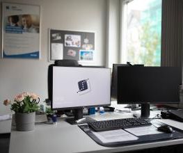Arbeitsplatz mit 2 Bildschirmen. Auf einem Bildschirm ist das WBS Logo zu sehen.