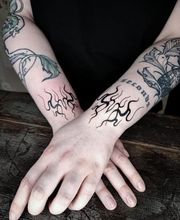 Filigrane, flammenartige Blackwork Neo-tribal Tattoos an beiden Unterarmen.