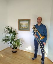 Das Bass-Flügelhorn wird in aufrechter Position in einem hellen Innenraum präsentiert.