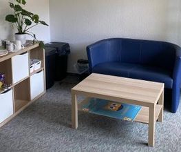 Ein Pausenbereich mit Couch und Couchtisch.