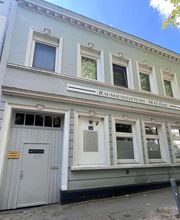 Martin Otto Thie Raumgestaltung Inh. Aline Sander e.K. Außenansicht eines traditionellen Werkstattgebäudes mit Schriftzug und klarer Struktur. Verbindung von Handwerkstradition und moderner Innenraumgestaltung.