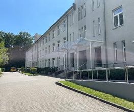 Ein dreistöckiges Gebäude und eine gepflasterte Straße.