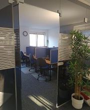 Arbeitsbereich mit Tischen, Stühlen und Bildschirmen