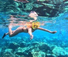 mujer blanca en agua cristalina del mar haciendo snorkel