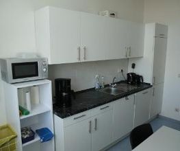 Küchenzeile in Salzgitter mit Mikrowelle, Wasserkocher und Waschbecken.