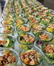 dean&david Catering | Pforzheim - Reihenweise Lachs Bowls im Glas mit Avocado, Mango, Salat, Sesam und cremigem Dressing als modernes Fingerfood für Veranstaltungen.