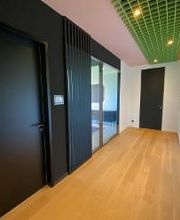 Länglicher Flur, seitlich Eingangsbereich des Trainingsraumes, bunte Deko-Haken an der gegenüberliegenden Wand