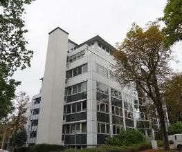 Gebäude mit mehreren Fenstern und einem Parkplatz.