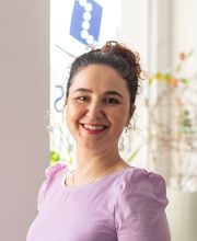 Das Bild zeigt Hatice Ilbasmis, Bildungsreferentin im Bereich Umschulungen bei WBS TRAINING. Sie lächelt herzlich, trägt ein fliederfarbenes Oberteil und steht vor einem hellen Hintergrund. Ihr freundliches Auftreten vermittelt Offenheit und Kompetenz