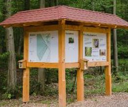 Eine Informationstafel markiert den Eingang des FriedWald Dietzenbach und macht auf den Wald als letzte Ruhestätte aufmerksam.