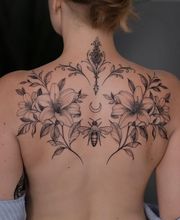 Eine Biene, mit Ornamenten und Blumen, symmetrisch auf den Schulterblättern angebracht.