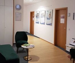Empfang Schulungsgebäude mit Sesseln und kleinen Tischen.