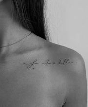 Fineline Schriftzug-Tattoo "La vita è bella" auf der Schulter mit eleganten Linien in filigraner Handschrift.