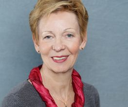 Frau mit kurzen blonden Haaren und rotem Schal.
