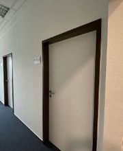 Ein Bild vom hellen Flur mit 2 weißen Türen und einem Fenster.