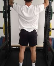 LIFE PERFORMANCE TRAINING | Personal Training Nürnberg - Rückansicht eines Athleten bei der Military Press mit der Langhantel, effektives Schultertraining für Haltung, Stabilität und Kraftaufbau.