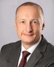 Portrait des Standortleiters. Ein Mann im Anzug mit Krawatte. 