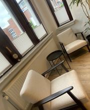 Aufenthaltsbereich mit Tischen und Sesseln.