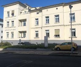 Gelbes Haus mit Beschilderung der WBS TRAINING. 