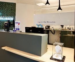 Blick in die offen gestaltete Werkstatt hinter einer Glasscheibe.