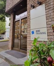 Äußere Eingangstür mit Firmenschild auf dem „WBS TRAINING“ steht.