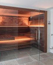 Individuelle Einbausauna in Nussbaum mit Salzsteinen und Glasfront für Zuhause. Maßanfertigung der corso sauna manufaktur. Saunahersteller seit 1968. Made in Germany.