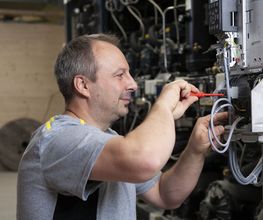 Unser Servicetechniker für Antriebstechnik, bei der Arbeit an einem Danfoss Frequenzumrichter.
