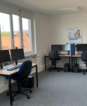 PC-Arbeitsplätze mit mehreren Monitoren, Tastatur, Maus und Headset.
