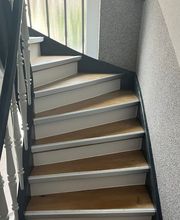 Das Bild zeigt eine fachgerecht mit Laminat belegte Treppe. Die Stufen wurden passgenau verkleidet, inklusive sauberer Kantenbearbeitung und farblich abgestimmter Leisten – für ein harmonisches Gesamtbild.