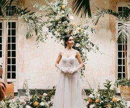 One of our brides posing with floral arrangements
